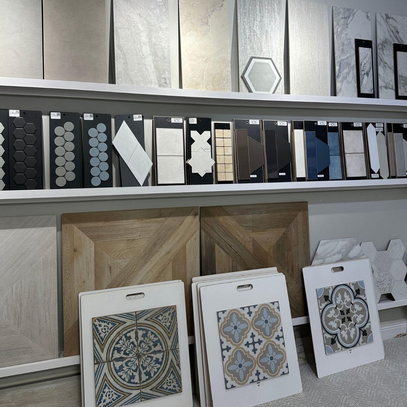 Showroom display with geometric mosaics, patterned tiles, and wood-look designs.