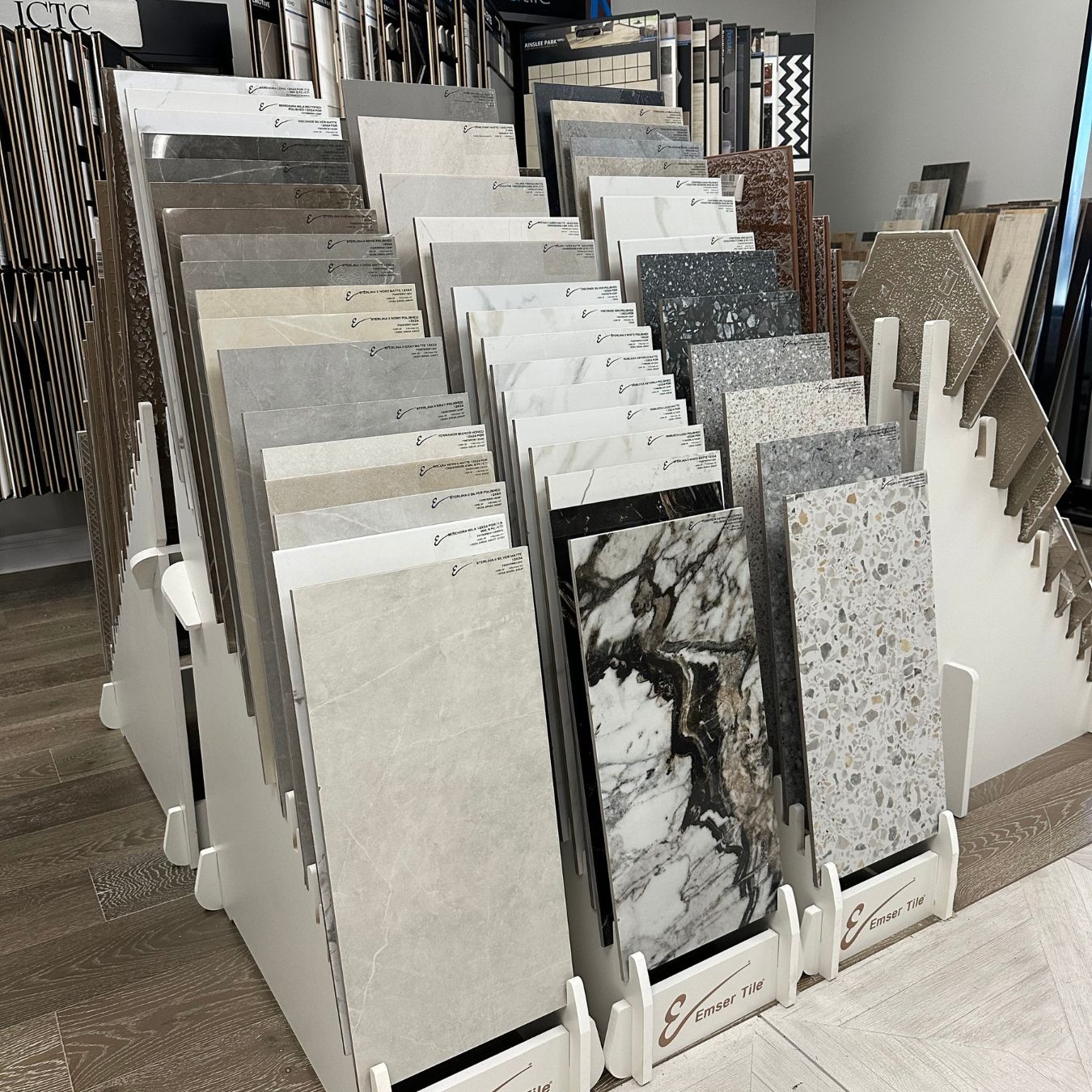 Emser Tile sample racks featuring neutral, marble-look, and terrazzo-look designs.